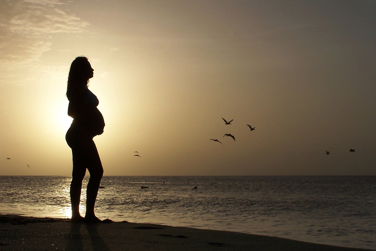 pregnant woman looking out over the water, fertility and chiropractic care