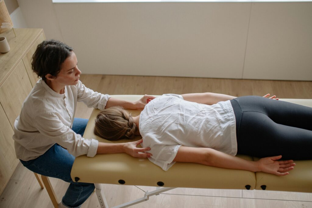 Woman laying on a chiropractic table getting ready for an adjustment. Fertility readiness, getting pregnant, chiropractic care for pregnancy. 