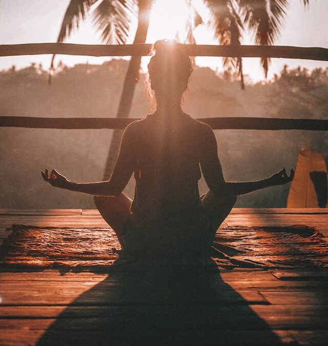Woman doing meditation at sunrise