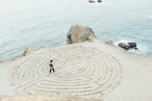 Person walking on the beach in a maze