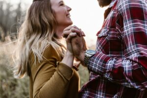 Man and woman clasping hands thinking about having a baby